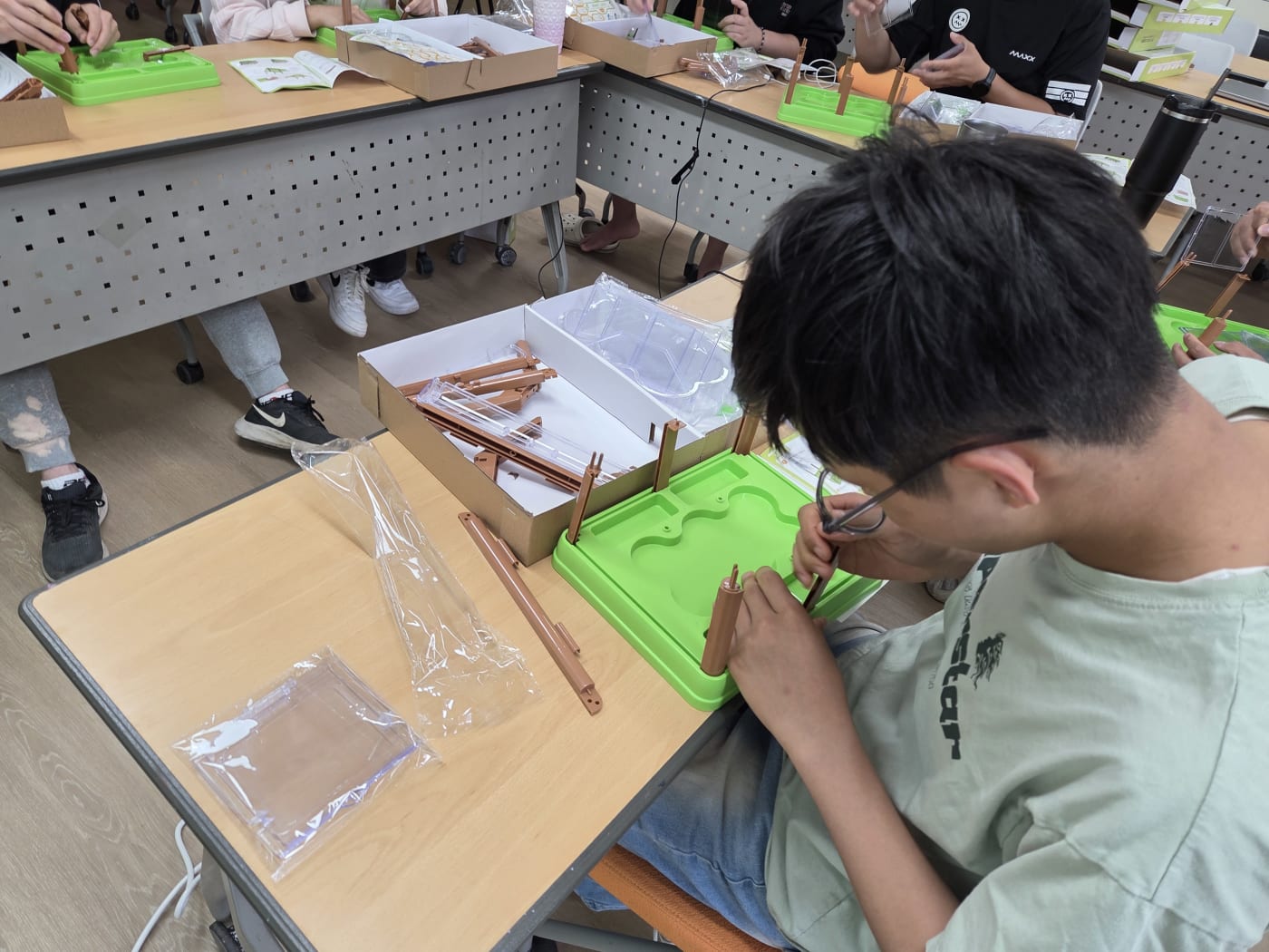 친구들과 함께 협동하며 각자의 스마트팜을 완성해가는 열기 가득한 교실의 풍경입니다.