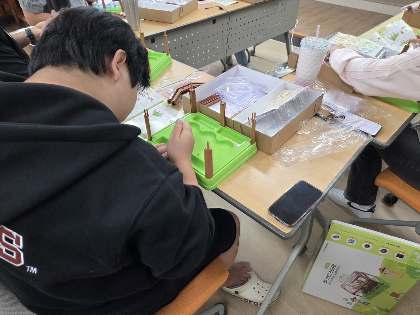 교육용 키트의 박스와 매뉴얼을 보며 스마트팜 온실의 기초 뼈대를 세우는 과정입니다.