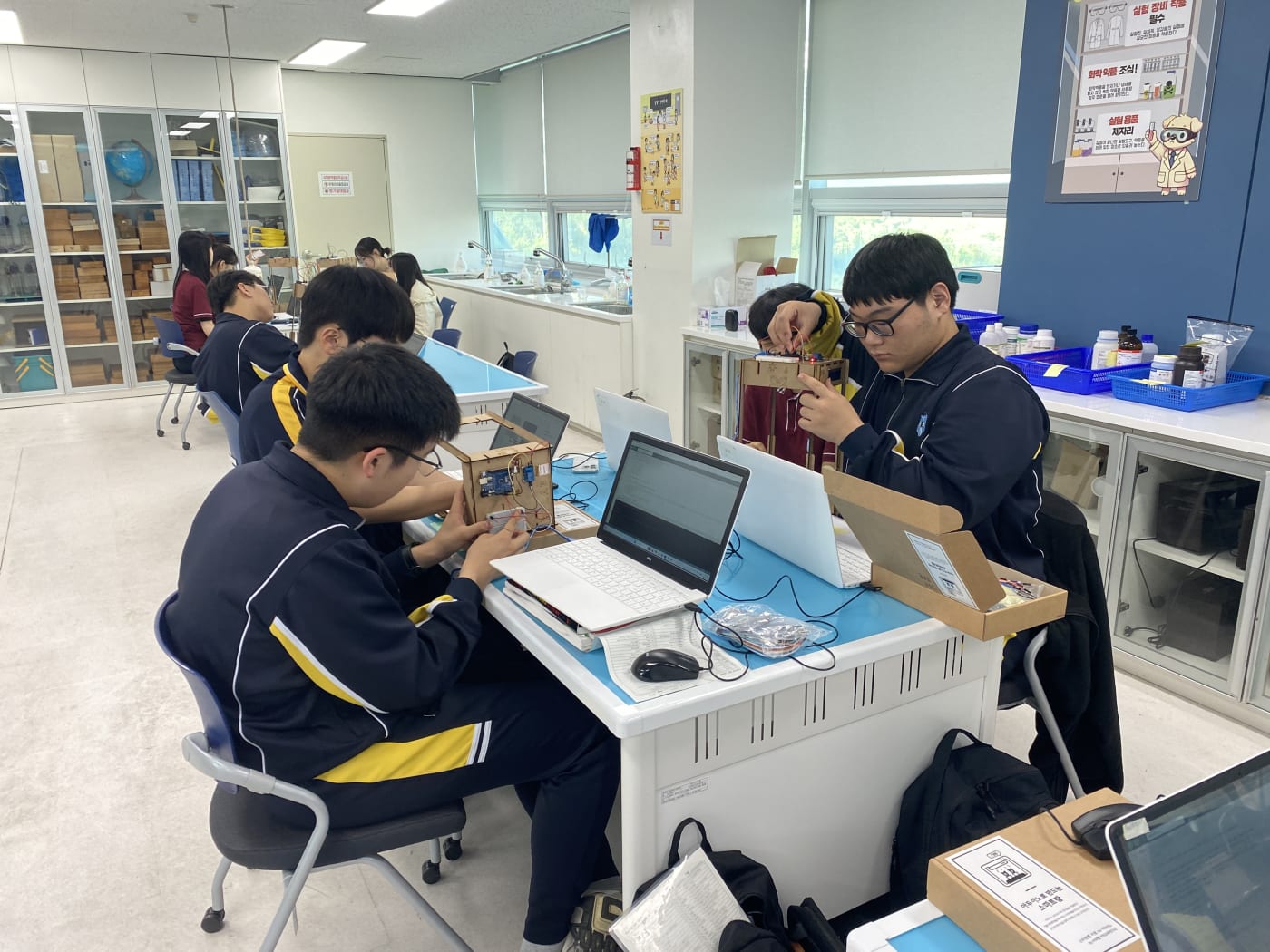 학생들이 아두이노와 브레드보드를 사용하여 I2C LCD 회로를 직접 연결하며 하드웨어의 원리를 세밀하게 익히는 집중도 높은 모습입니다.