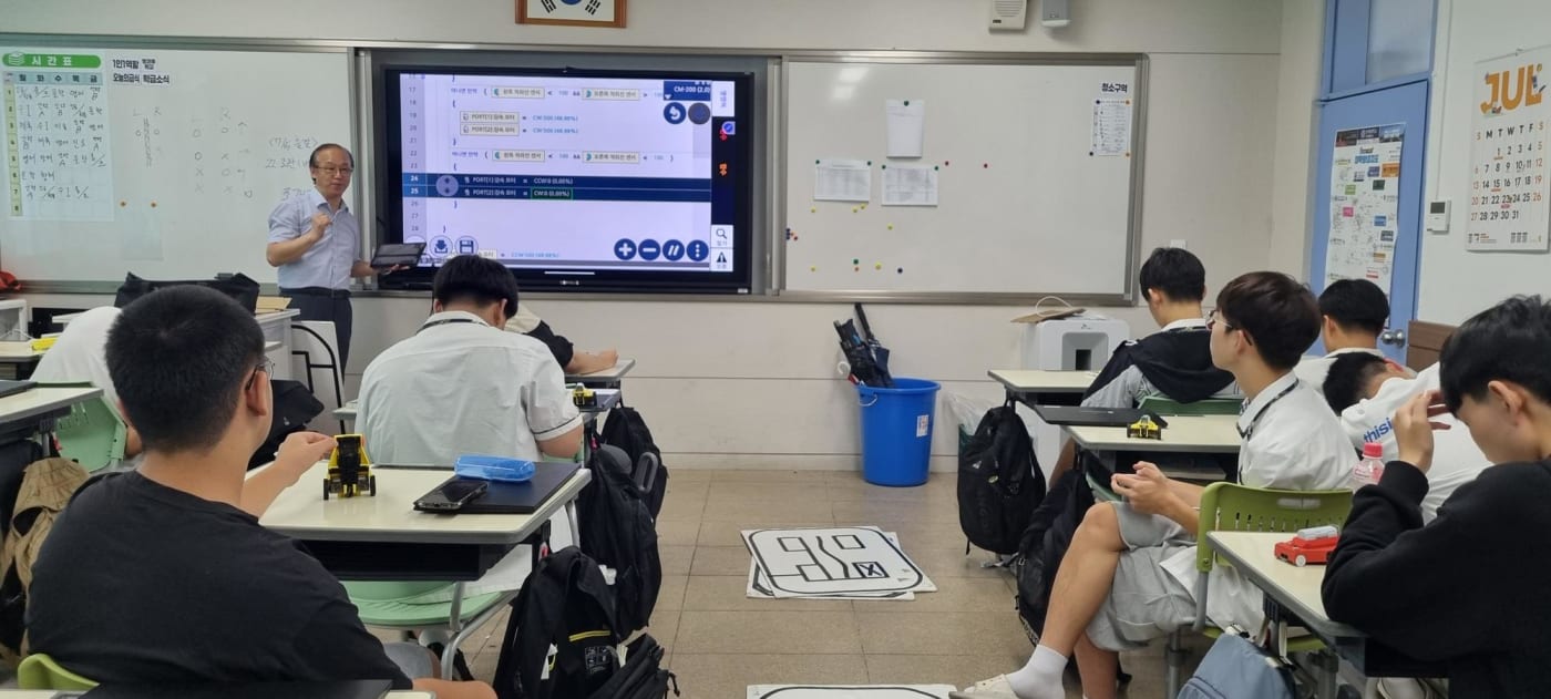 강사가 학생들에게 코딩과 기술을 열정적으로 지도하는 모습입니다.