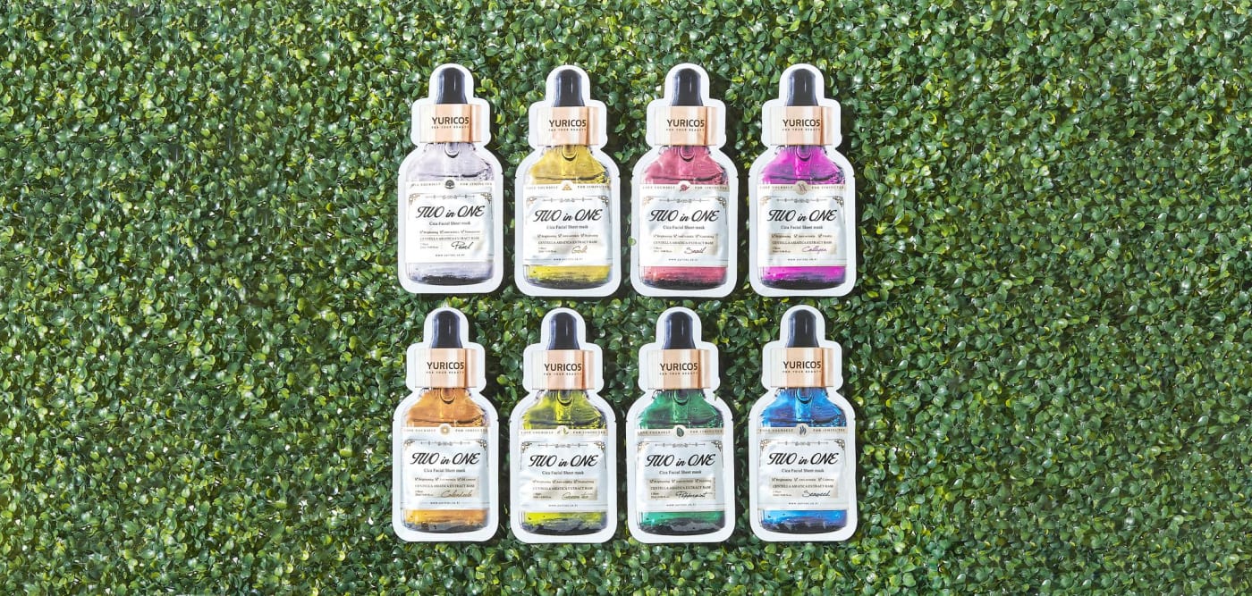 A lineup of YURICO5 Two in One Cica Mask packages in various types against a green background