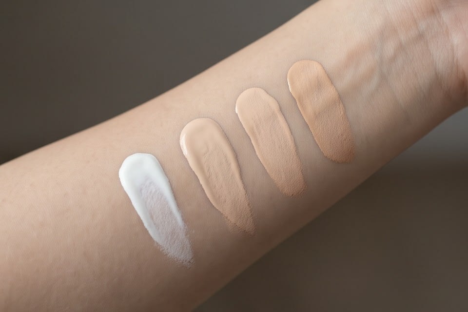 Sunscreen and base products in various colors applied to an arm