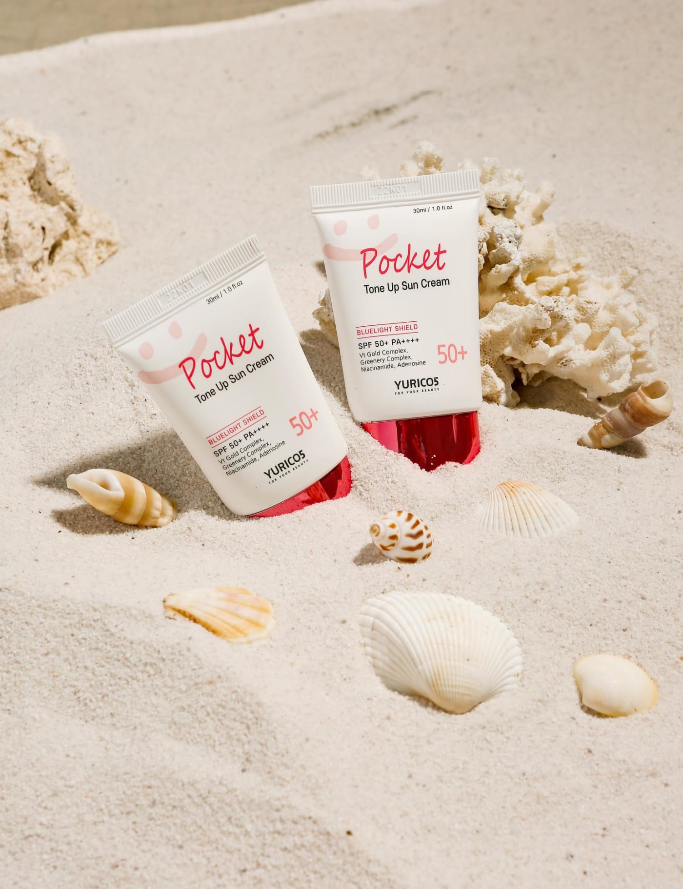 Pocket tone up sunscreen styled against a beach sand background