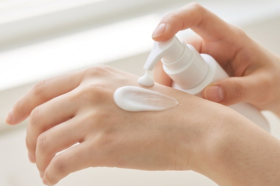 Checking spreadability by applying a soft-textured cream to the back of the hand