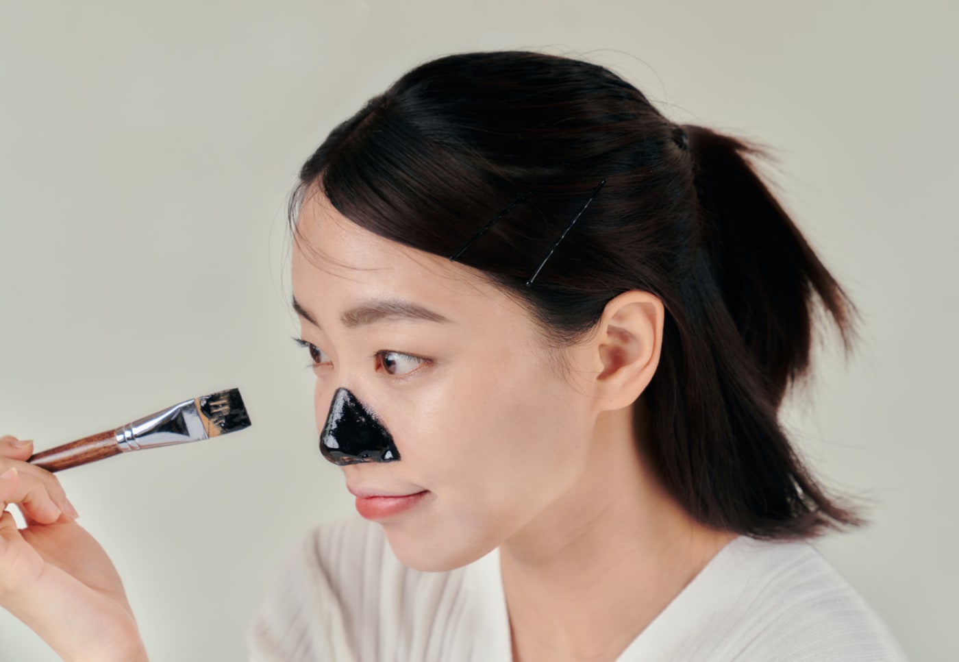 A black formula mask applied to the nose