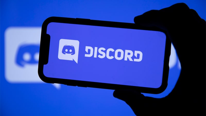 Foto de um computador aberto na tela do discord e um celular com o icone do Discord