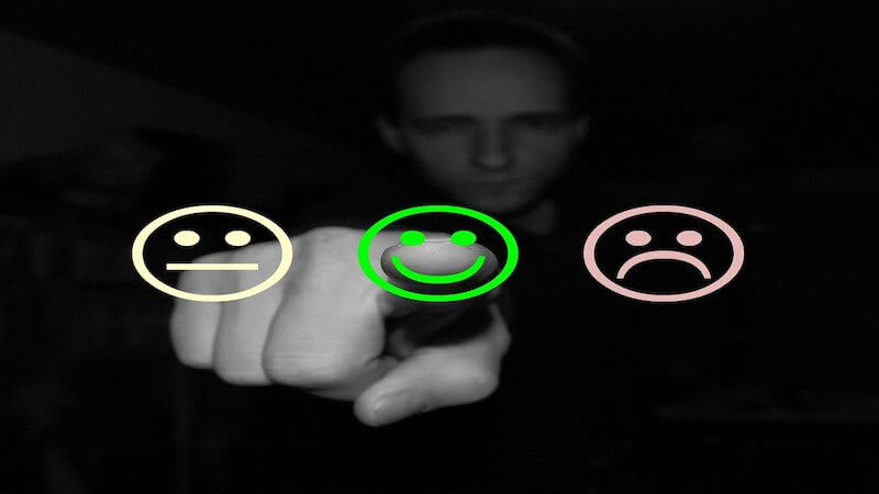 The image shows a person pointing to a smiley face