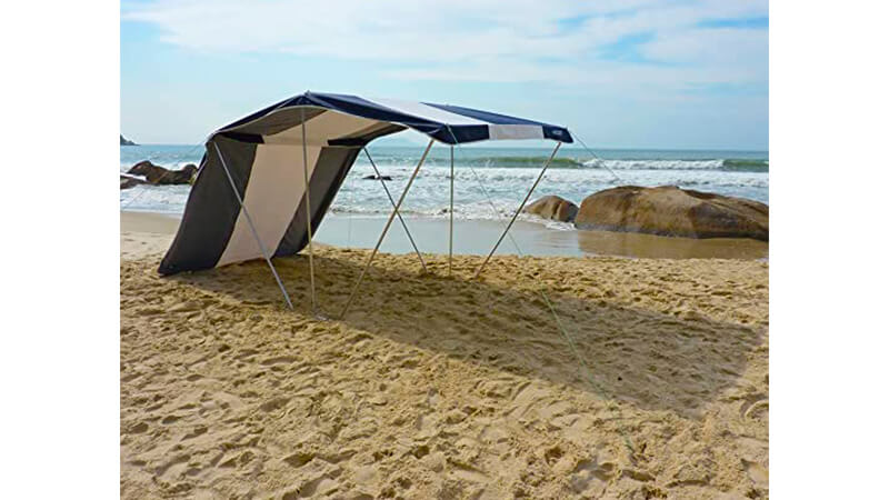 imagem que mostra uma tenda Poseidon Zaka na cor branca e azul instalado em uma praia