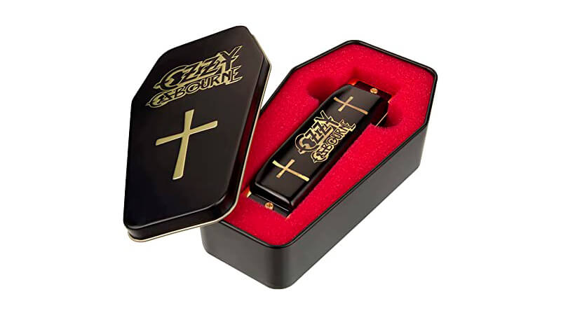 imagem de uma gaita Hohner edição especial do Ozzy Osbourne dentro de uma caixa de metal em formato de caixão