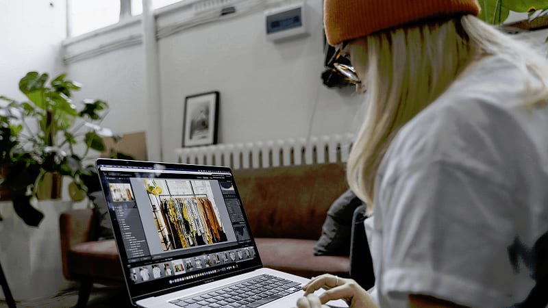 The image shows a woman using a laptop