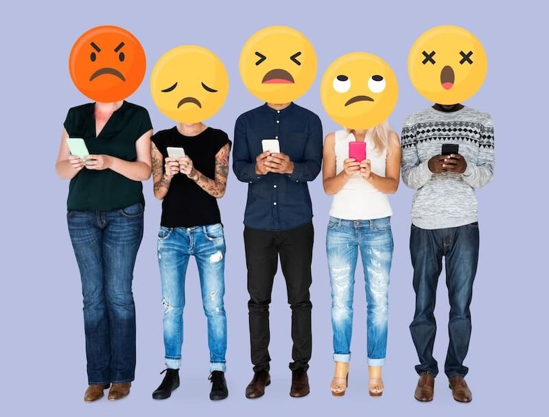 The image shows 5 people holding smartphones. Their heads are covered with emojis. 