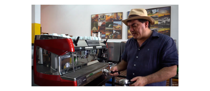 Instrutor do curso de barista mostrando componentes de uma máquina de espresso