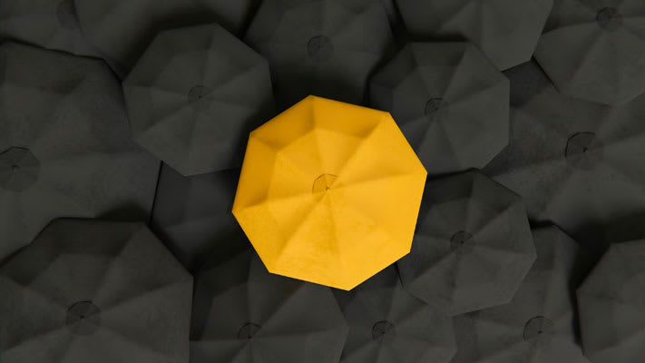 Foto de un paraguas amarillo destacándose en medio a paraguas pretos
