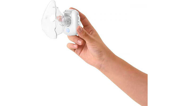 imagem de um nebulizador portátil da Multilaser na cor branca sendo segurado por uma mão feminina
