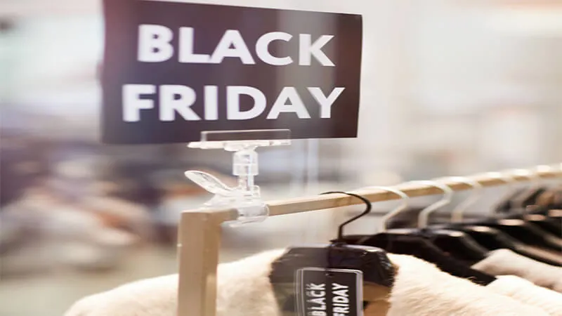 Foto de uma arara de loja com uma placa escrito Black Friday