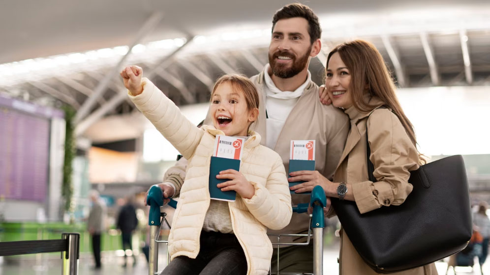 Foto de una familia en el aeropuerto, cada uno con su pasaporte en mano.