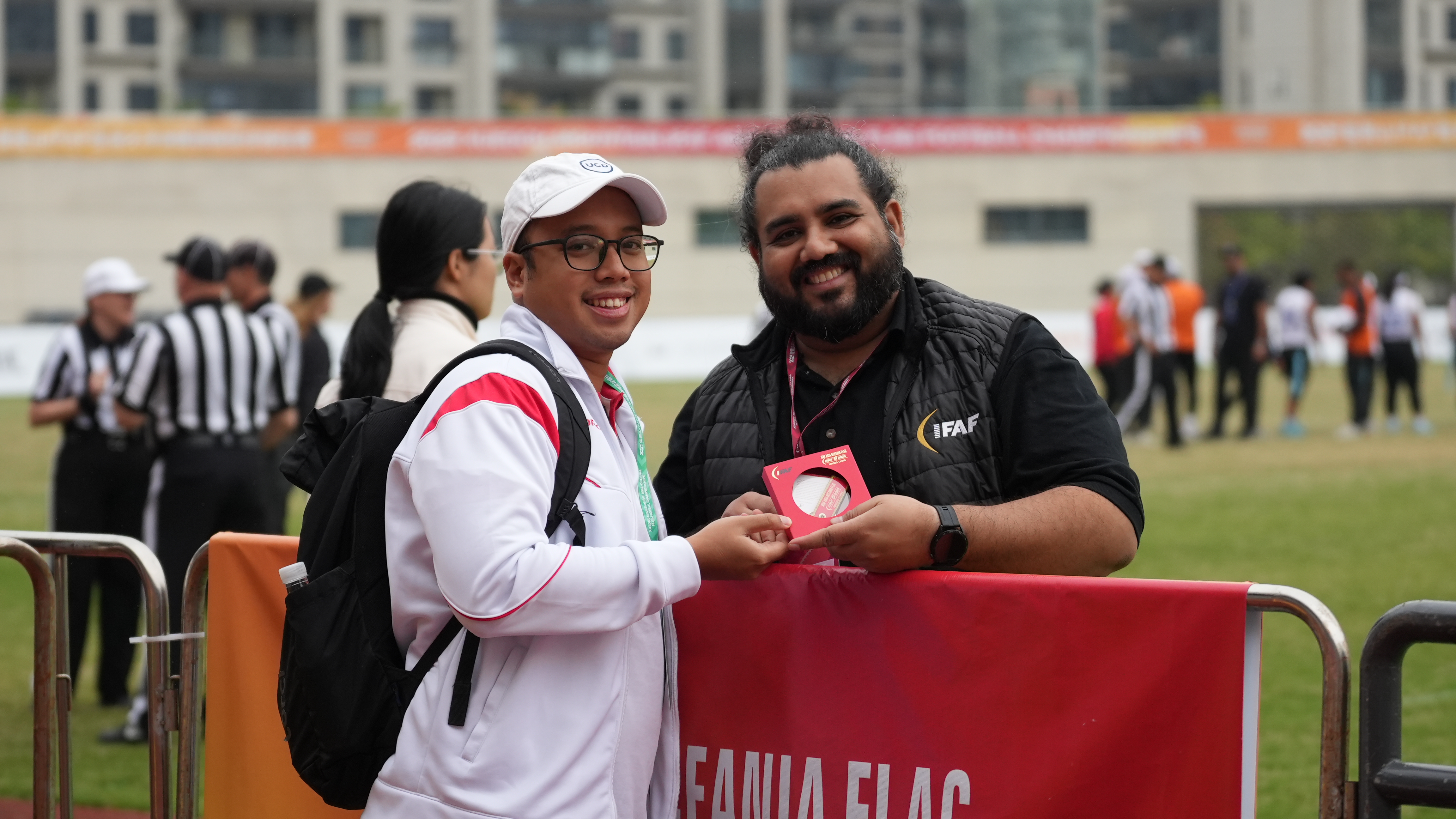 General Manager Tim Nasional Flag Football Indonesia berfoto bersama Direktur IFAF untuk Asia di pinggir lapangan pada IFAF Asia-Oceania 2025, Ningbo.