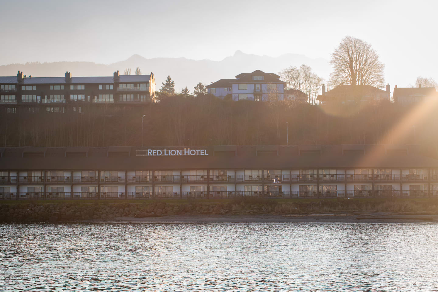 Red Lion Hotel building backlit by golden sunset light with mountains behind