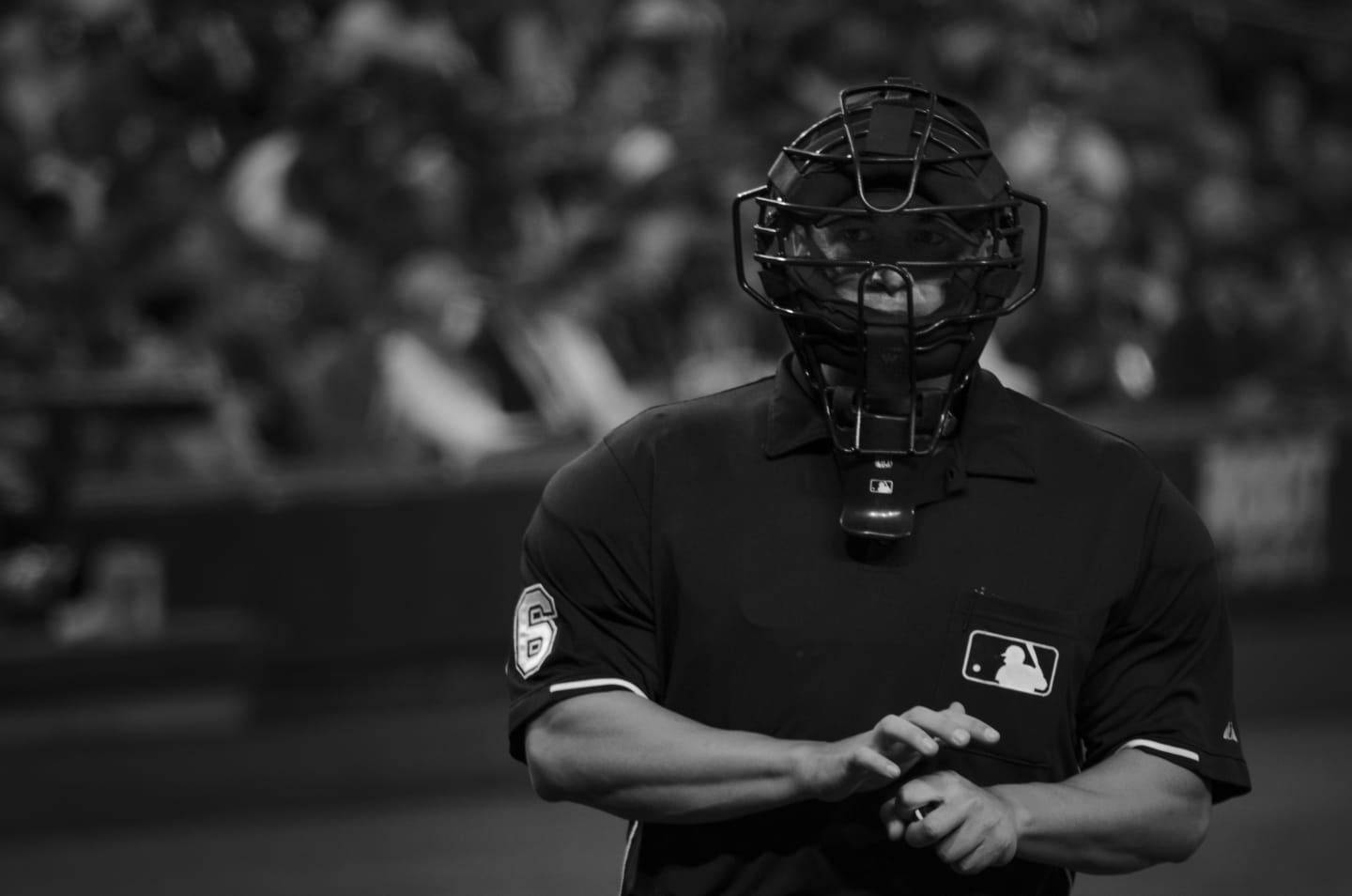 Black and white photo of home plate umpire in protective gear during play