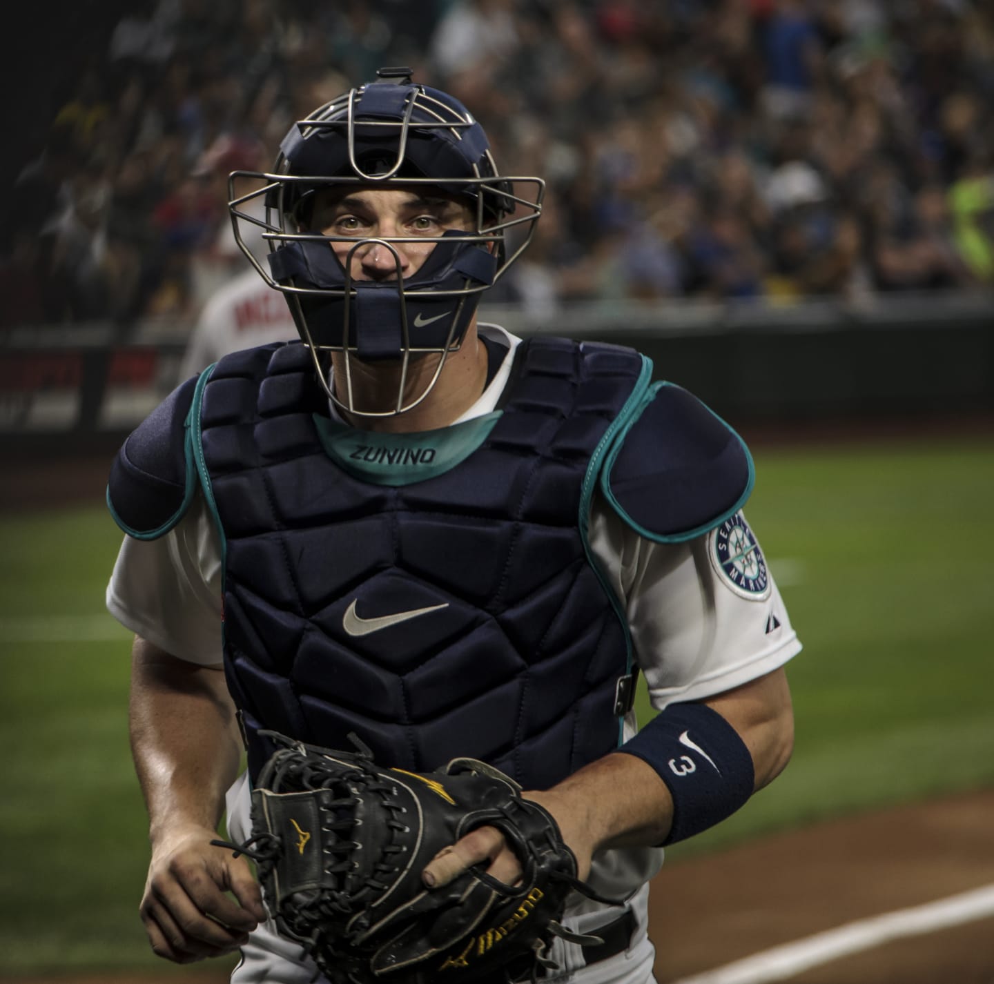 Black and white portrait of a Mariners player adjusting his cap, looking contemplative