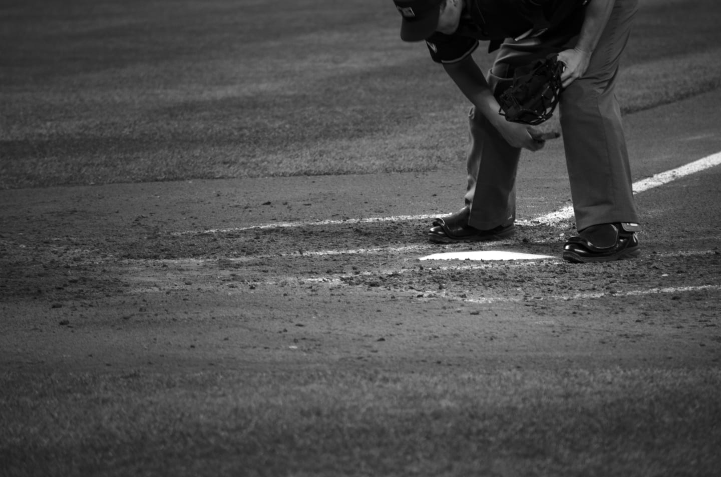 Color action shot of Angels batter mid-swing with Mariners catcher and umpire