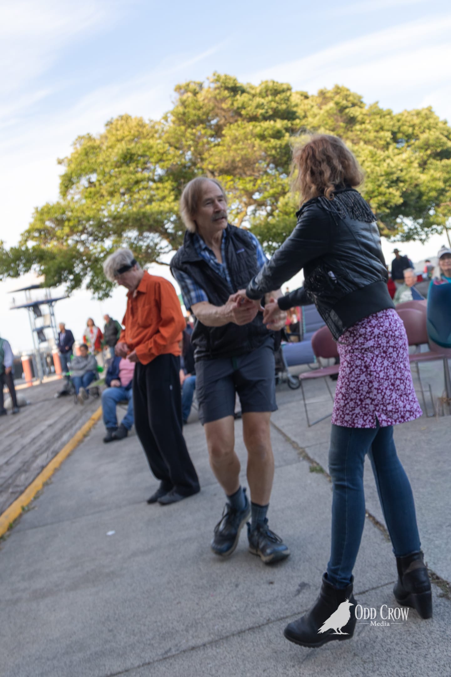 Couple dancing together on the waterfront at Concerts on the Pier in Port Angeles, with audience members seated in folding chairs around them