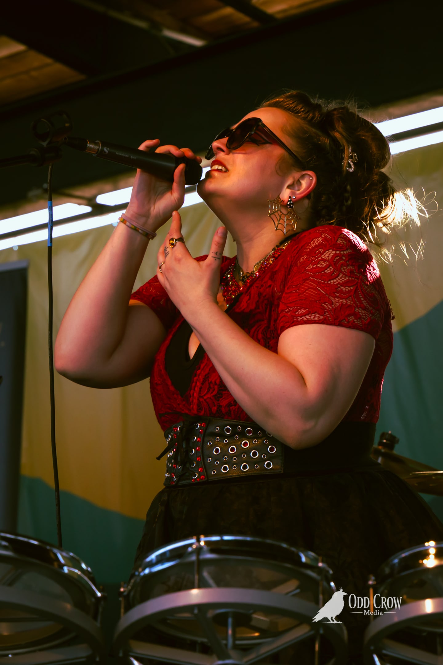 Bee Smith belting into the mic, backlit by the pier's string lights