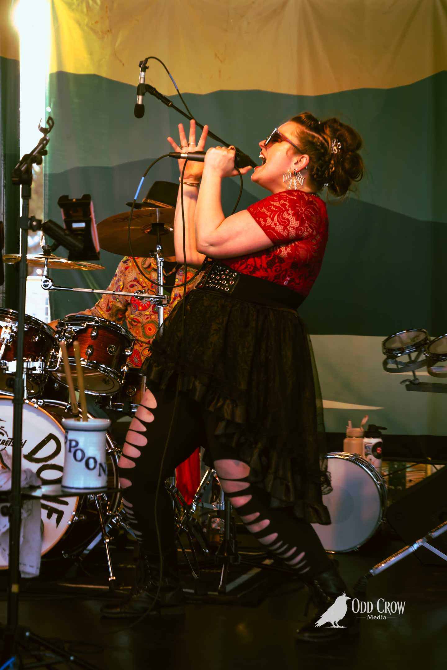 Bee Smith mid-note in a wide stance in front of the drum kit's Reckless Dove head