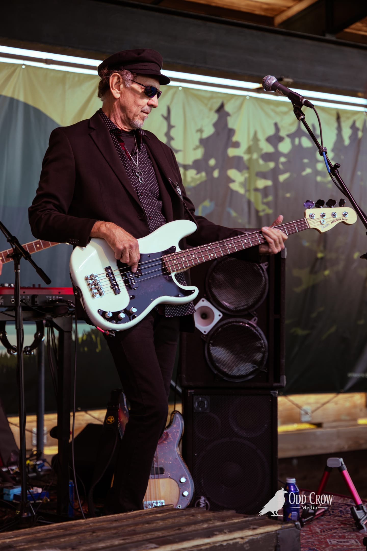 Petty Fever front man in top hat, red shirt, and black blazer playing Rickenbacker guitar with Yamaha keyboard player visible behind him