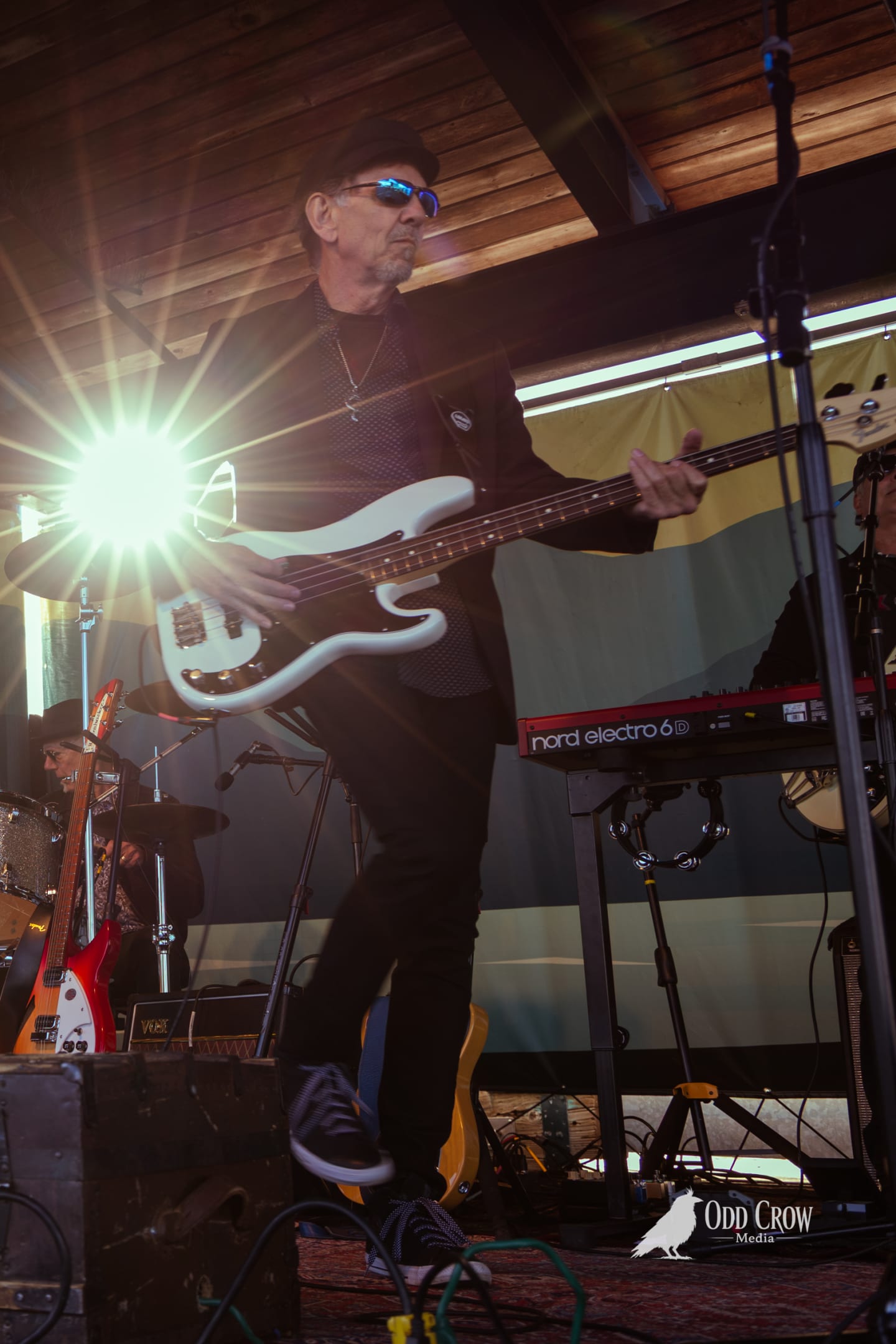 Petty Fever front man playing Rickenbacker guitar at an angle, hair catching the wind, energy mid-song