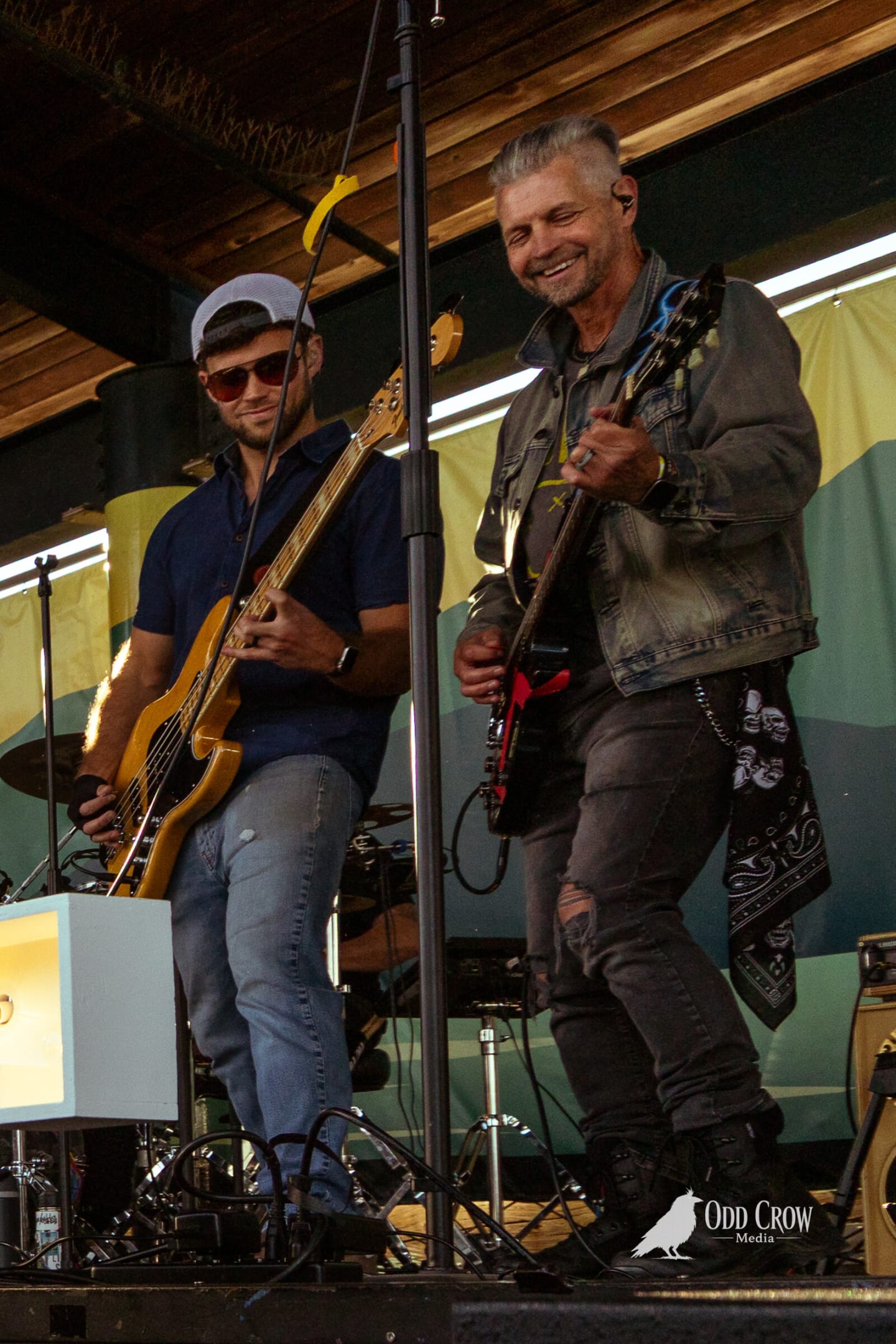 Bass player and guitarist grinning at each other on the Crabfest stage