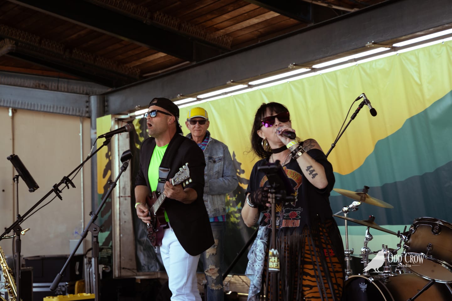 Guitarist, saxophone player and vocalist performing together on stage