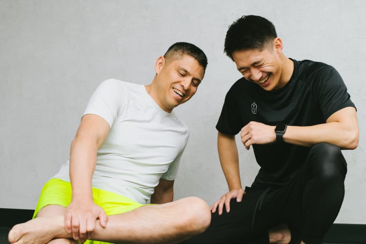 Trainer smiling while guiding client during training session