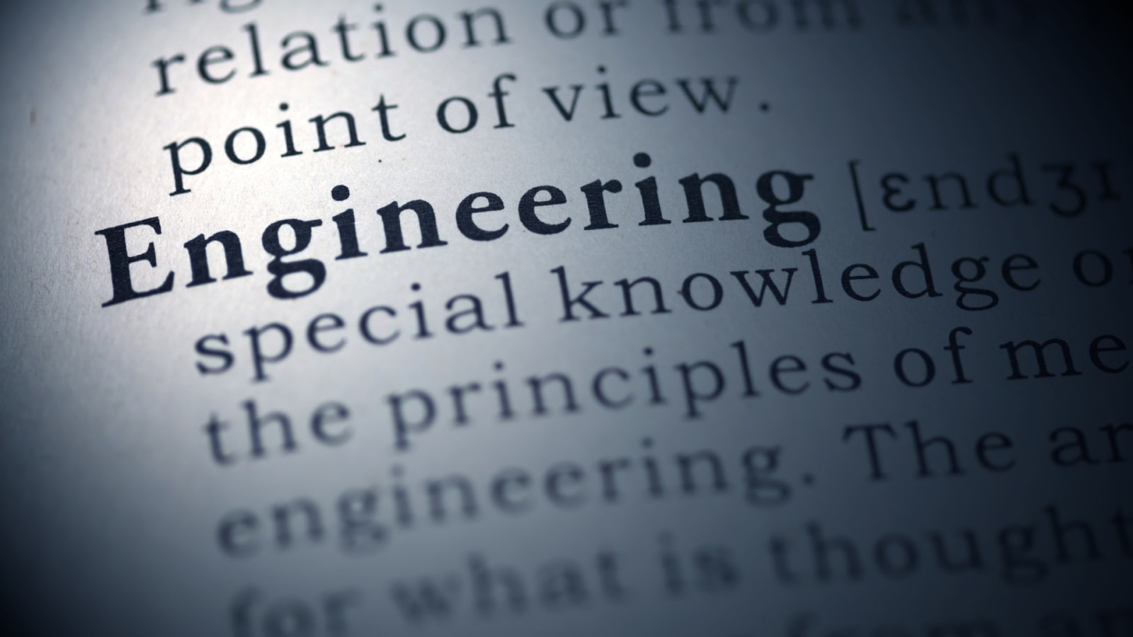 Engineers reviewing large-format engineering drawings around a project table