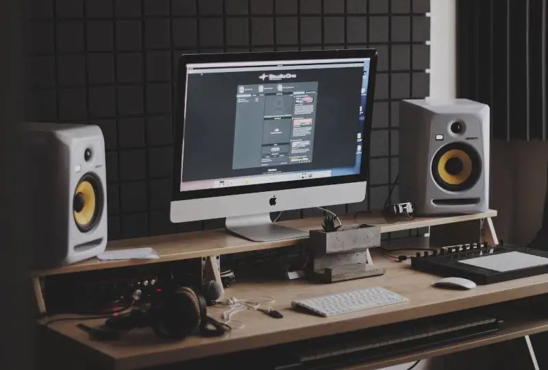 Image of a home studio with a computer, studio monitors and a DAW on screen