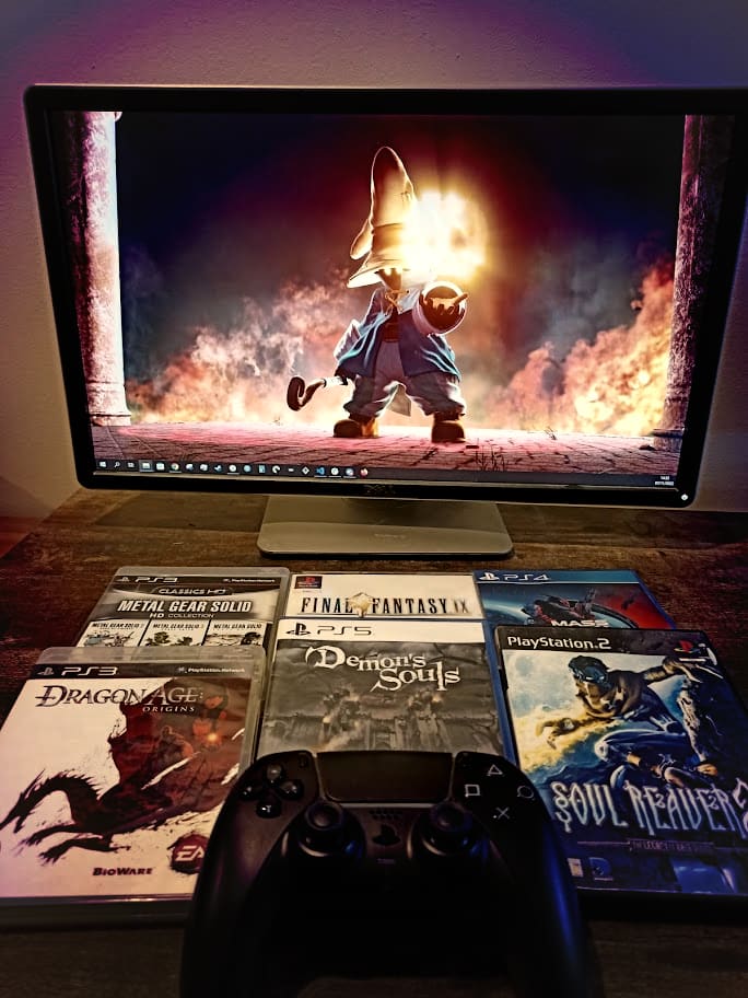 Photo of some of my favourite video games, with a picture of Final Fantasy 9's Vivi appearing on a monitor behind them.
