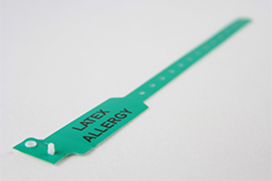 Green patient wristband for hospital admission with sizing holes, snap closure, and "LATEX ALLERGY" in large black text.