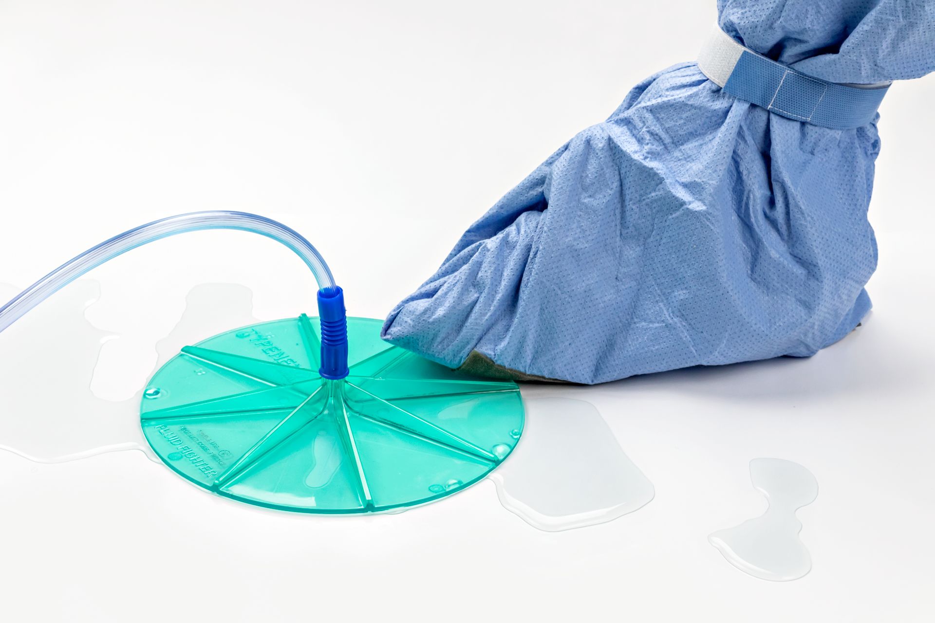 PPE covered foot on Fluid Fighter suction disc by Typenex Medical. Water around a teal, transparent, circular disc.