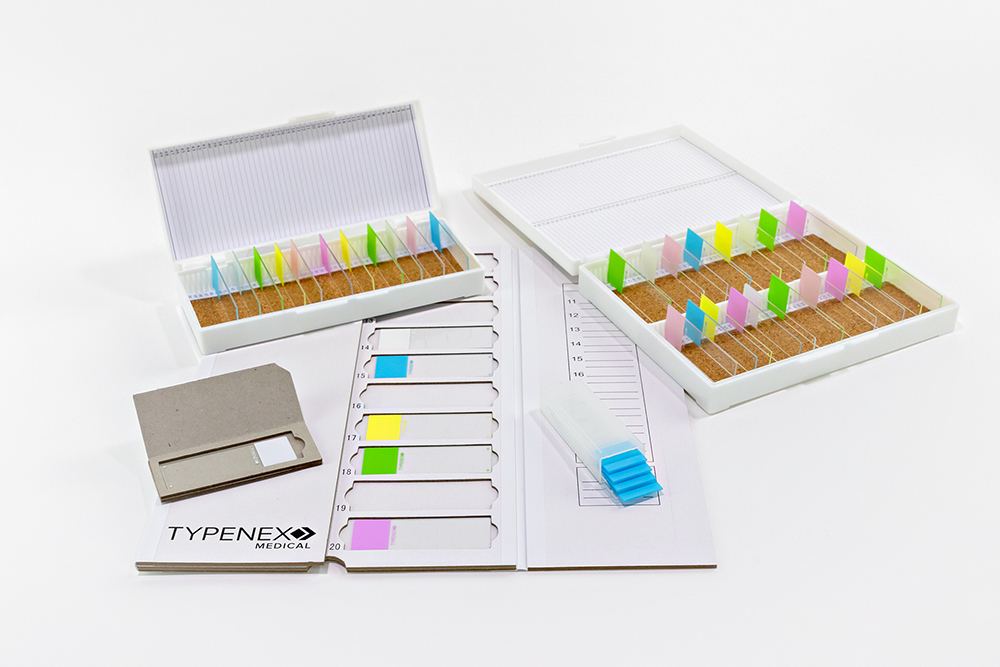 Two microscope slide storage boxes, a cardboard mailer folder with numerical indexes, a cardboard single slide mailer, plastic mailer case.