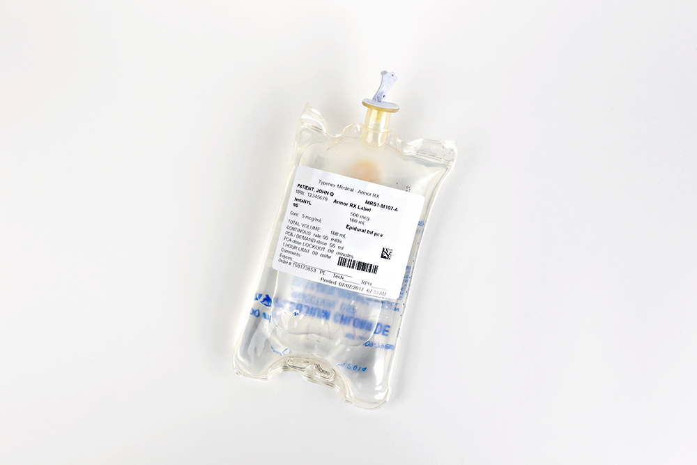 Typenex Medical ArmorRx Alcohol-Resistant Label with patient data and barcode, displayed on front of IV bag.