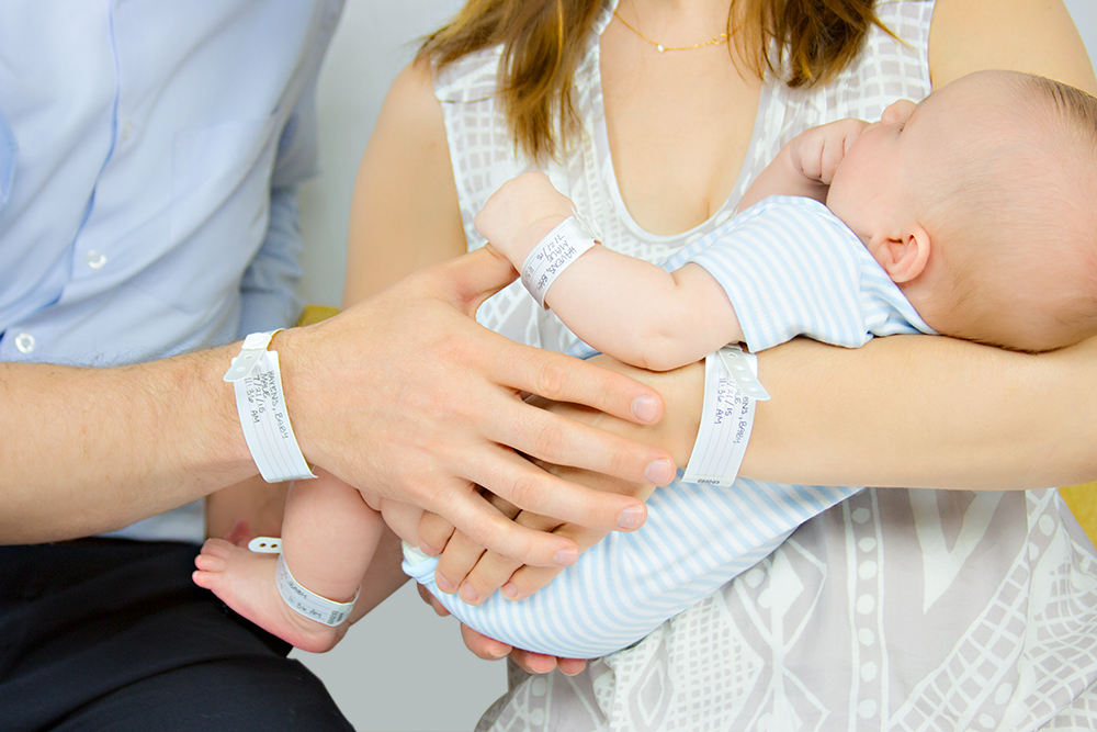 Parents and newborn child each wearing Typenex Medical FamBand 4-part patient identification wristband.