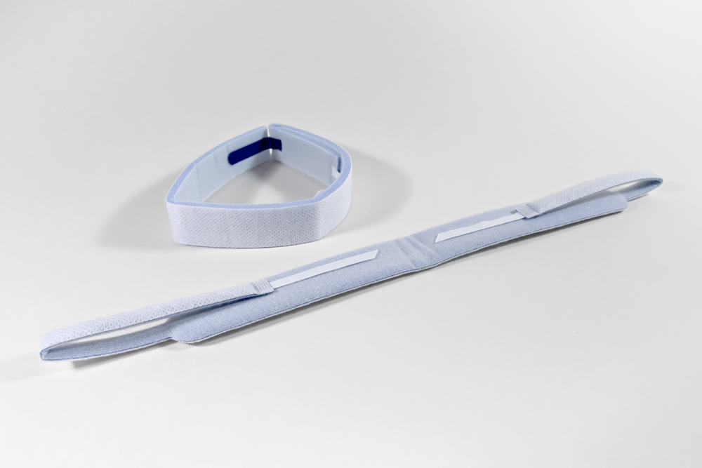 Two blue/white tracheostomy tube patient neckbands with soft foam material and Velcro hook tabs