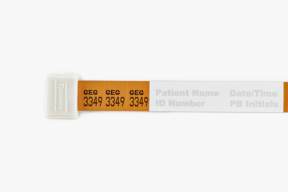 Close-up of orange Typenex Medical Original Blood Band (4R4612) with alphanumeric code and self-cutting clip.