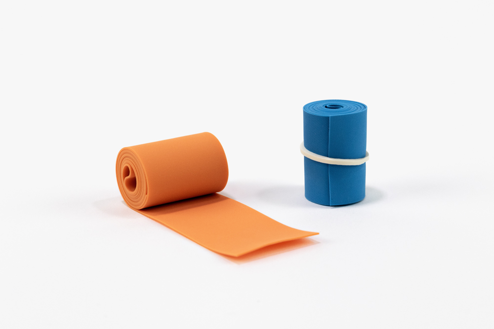 One orange tourniquet, one blue tourniquet rolled and rubber-banded.