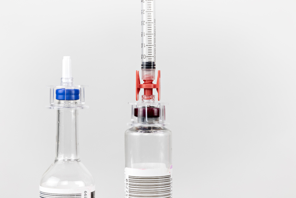 Left: CultureSafe Blood Culture Bottle Dispensing Device on a BD BACTEC culture bottle. Right: CultureSafe Blood Culture Bottle Dispensing Device, Sterile Guarded Luer Lock Connector, and a syringe on a bioMériuex BacT/ALERT SN culture bottle.