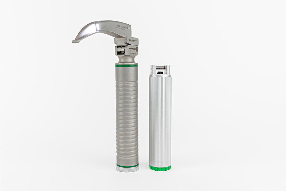 Reusable laryngoscope blade and handle, paired next to a separate disposable handle.