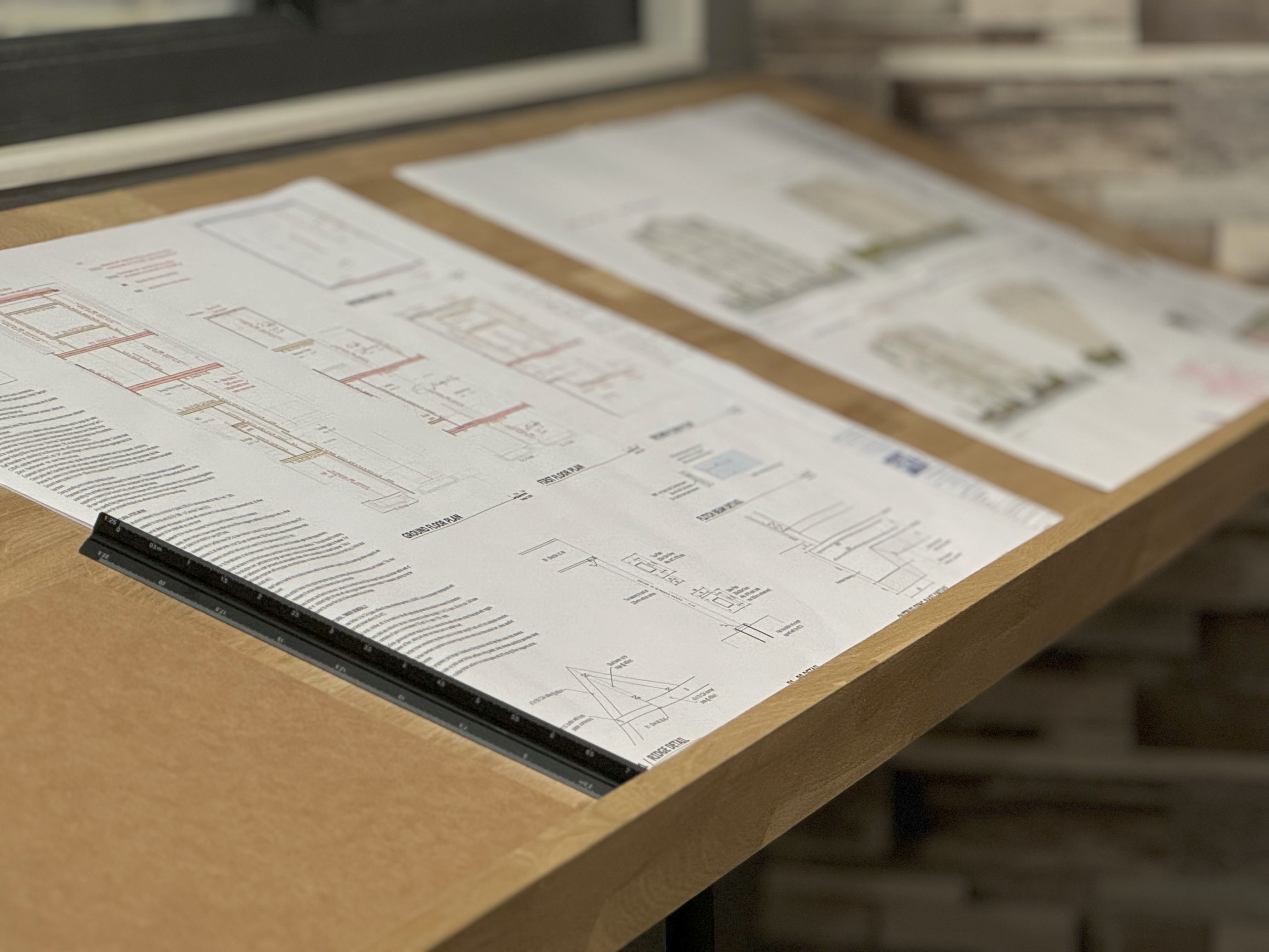 Construction plans on a wooden desk
