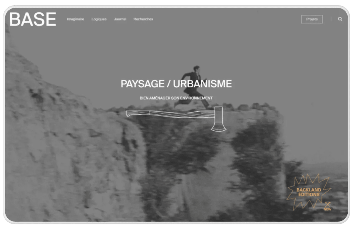A laptop displays a homepage with a fullscreen black and white animated image associated with main navigation elements like menu and links