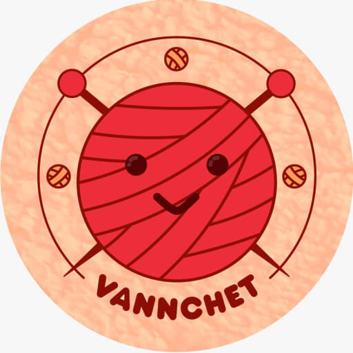 A ball of yarn with a happy face with two hooks behind it and three small ball of yarn