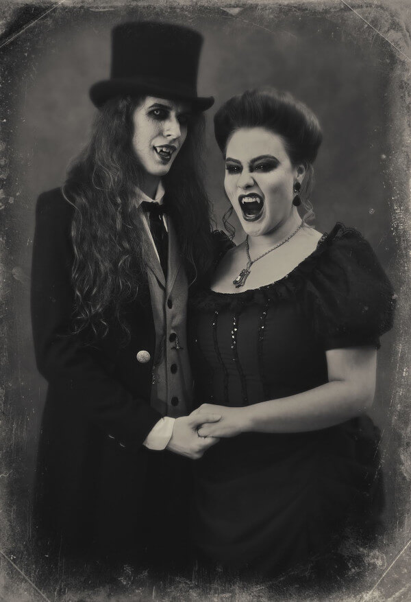 An old-timey, black and white themed photo where Royce and Courtney are dressed as Victorian Vampires and holding hands.